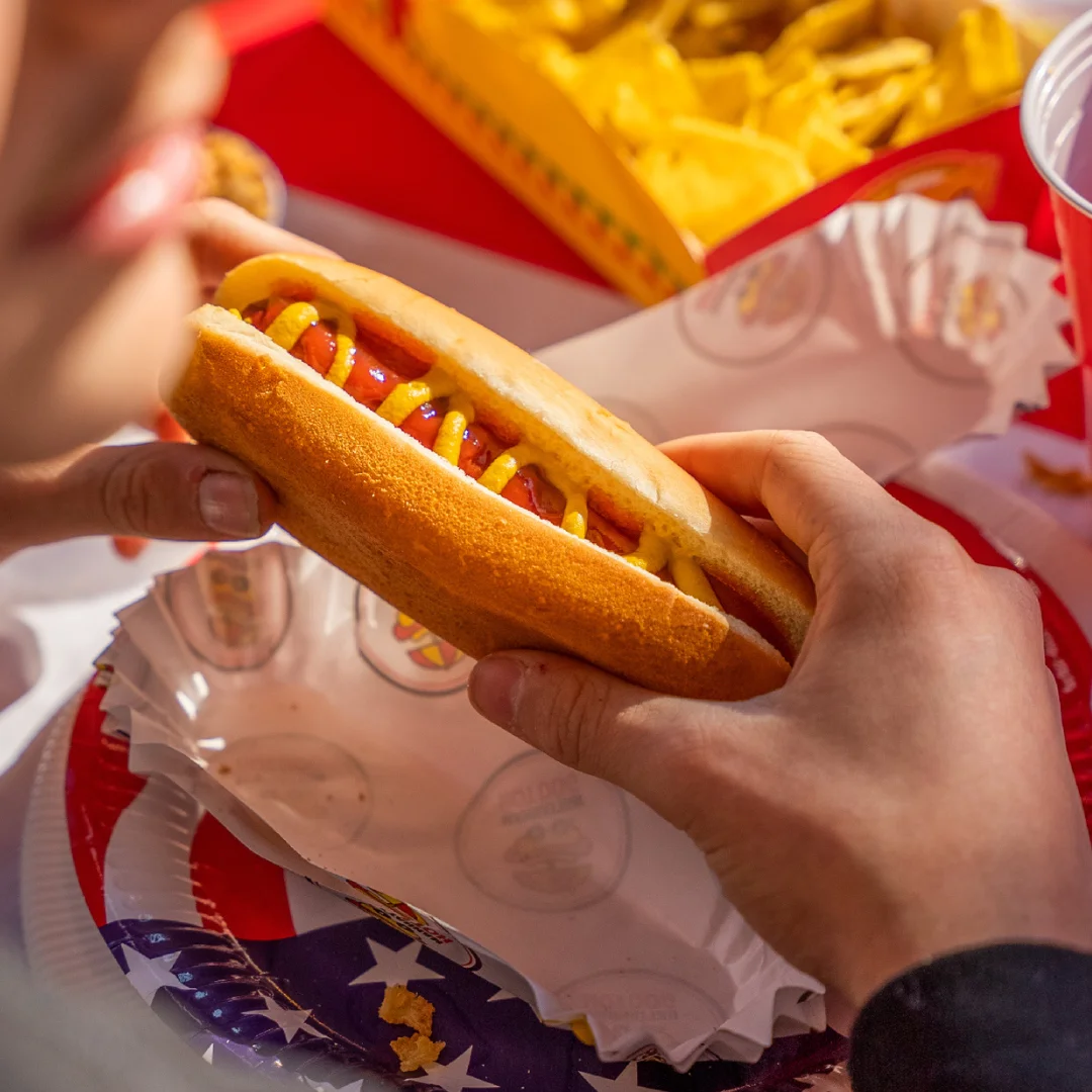Une personne dégustant un hot-dog Manhattan